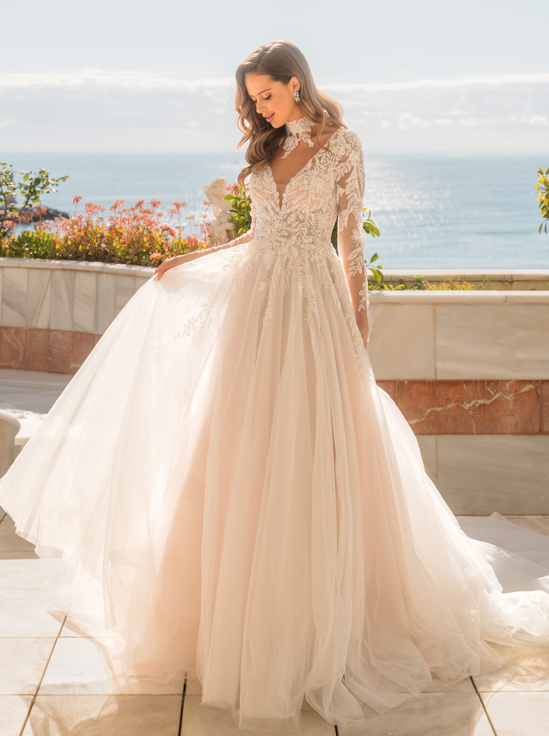 Romantisk brudklänning med broderad spets, skimrande tyllkjol och långa spetsärmar från Jolie Bridal i Malmö.