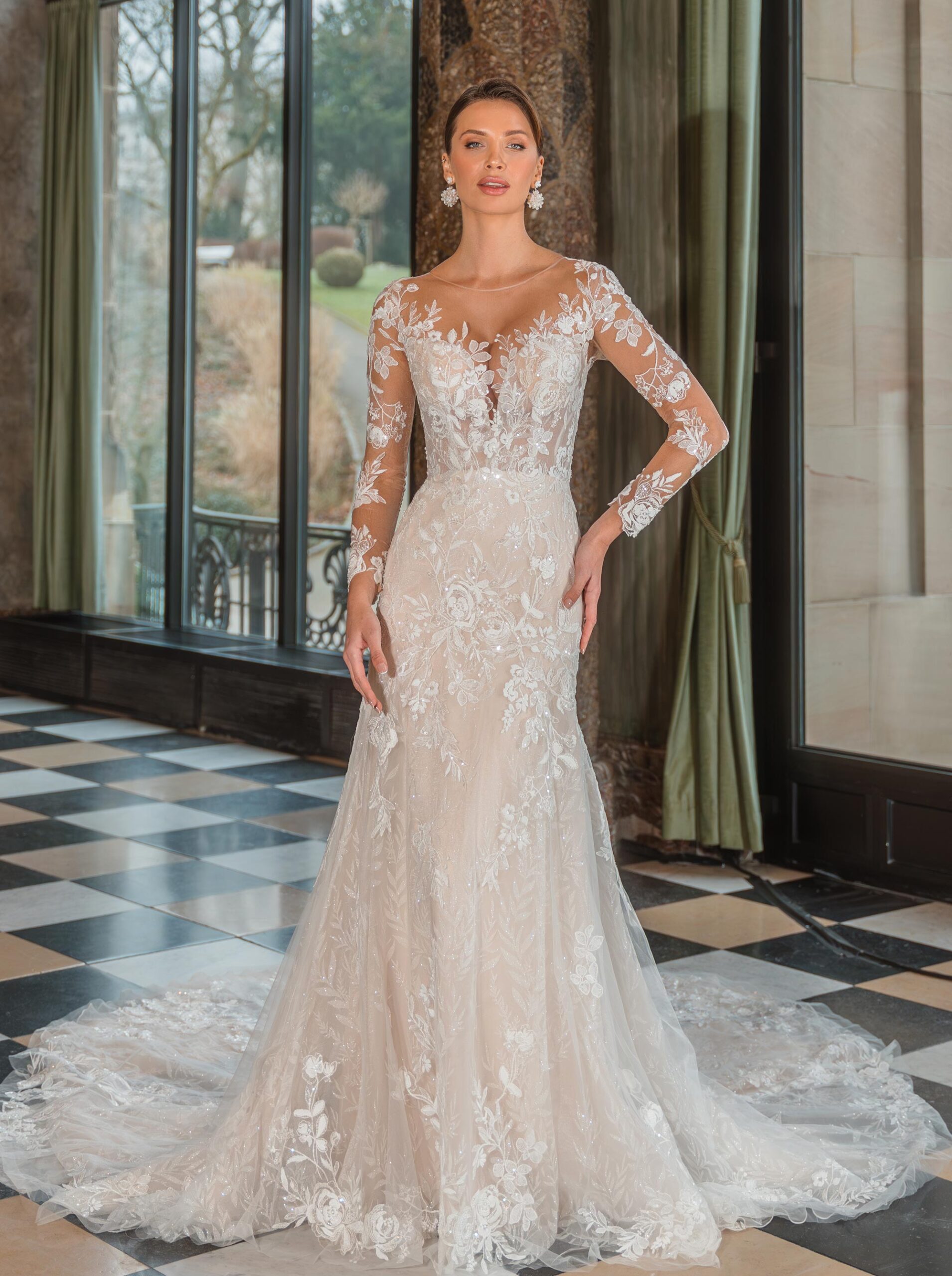 Brudklänning med transparent spetsliv, långa broderade ärmar och spetsbakdel – DE LUXE by Diane Legrand hos Jolie Bridal i Malmö.