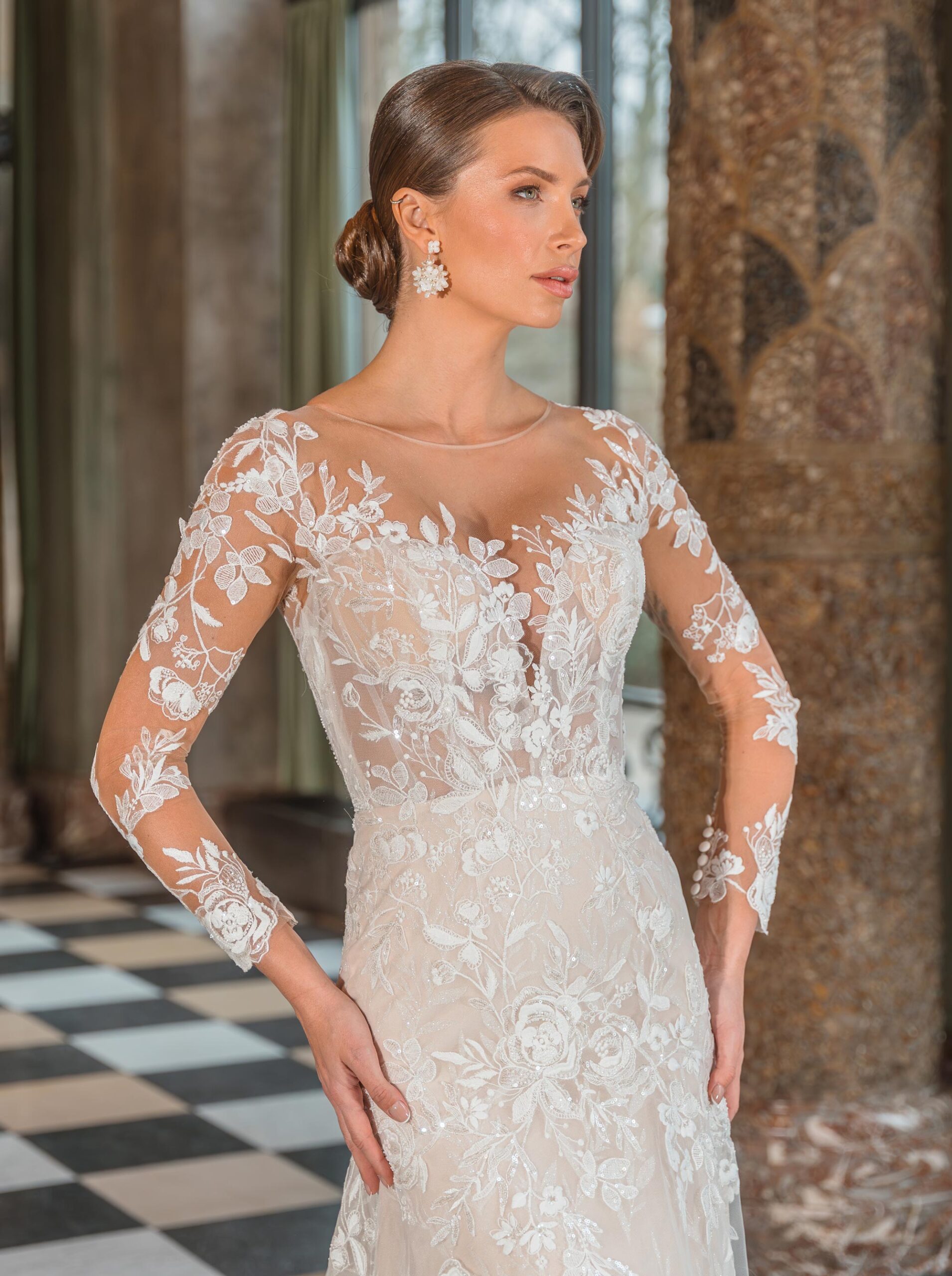 Brudklänning med transparent spetsliv, långa broderade ärmar och spetsbakdel – DE LUXE by Diane Legrand hos Jolie Bridal i Malmö.