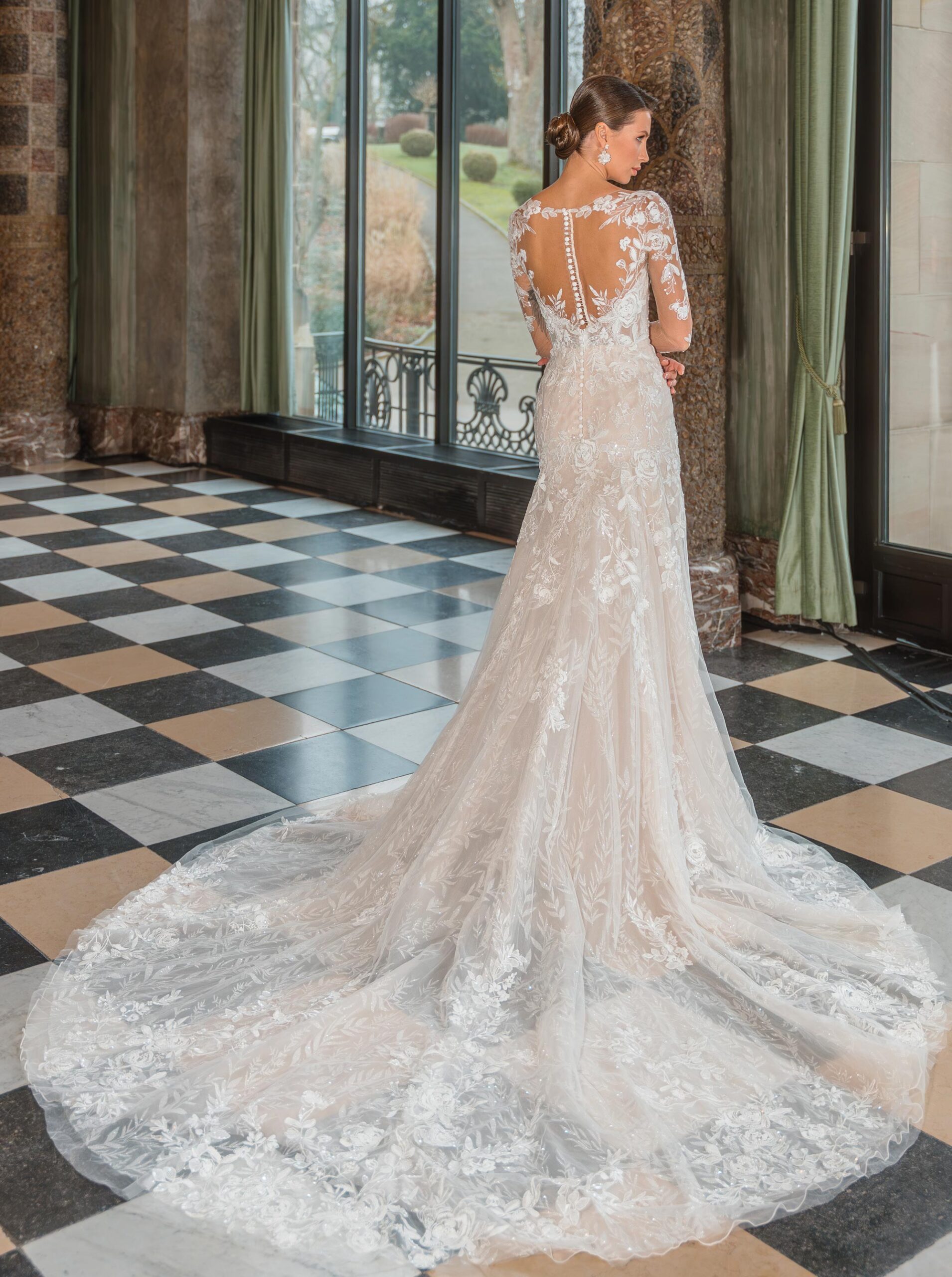 Brudklänning med transparent spetsliv, långa broderade ärmar och spetsbakdel – DE LUXE by Diane Legrand hos Jolie Bridal i Malmö.