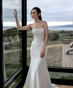 Fit & flare-klänning med cat eye-urringning, Basque-midja, glittrande pärlbroderier, transparent liv med korsett i ryggen och crepekjol med svepsläp.