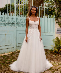 Tyllklänning i A-linje med rak urringning, tunna spetsband, illusionliv med synlig boning, matta spetsapplikationer, 3D-blommor i organza och galax-tyll med kapellsläp.