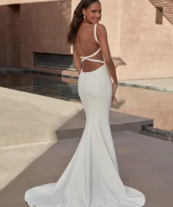 Romantisk brudklänning i crepe med fit and flare-siluett, låg nyckelhålsrygg och illusionband från Jolie Bridal i Malmö.